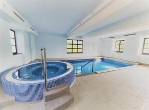 a large swimming pool with a blue tub in a room at Jurjevec Castle in Brežane Lekeničke
