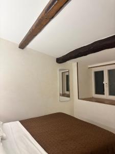 a bedroom with a bed and two windows at Deattellis House accogliente mansarda in palazzo storico in Campobasso