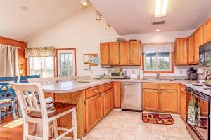 a kitchen with wooden cabinets and a counter top at Misty Blue - Corolla, Ocean Sands, 200 Yards to Beach, Ocean View, Pets OK, Flex Stays Year Rnd in Corolla