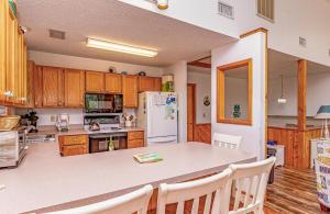 a kitchen with wooden cabinets and a white refrigerator at Misty Blue - Corolla, Ocean Sands, 200 Yards to Beach, Ocean View, Pets OK, Flex Stays Year Rnd in Corolla