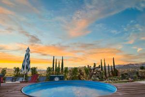 a large swimming pool with a sunset in the background at Rockaway Mesa Dome Views Pool Karaoke Sauna in Yucca Valley