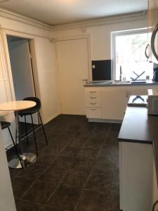a kitchen with a counter and a table and a window at Huset i Hammelev in Vojens