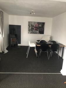 a room with a table and chairs and a fireplace at Huset i Hammelev in Vojens +3 photos