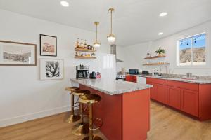 a kitchen with red cabinets and a counter top at Rockaway Mesa Dome Views Pool Karaoke Sauna in Yucca Valley