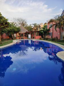a pool with blue water in front of a house at Casa Paraíso in Ixtapa