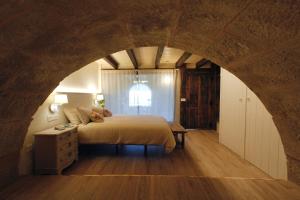 a bedroom with a bed and an archway at "Dobela Enea" Cueva alojamiento privado in Laguardia