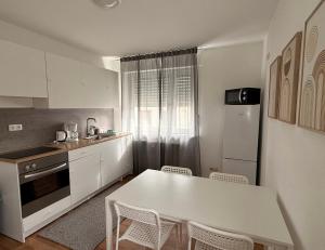 a kitchen with a white table and chairs in it at Ferienwohnungen Uhrturm in Oppenheim