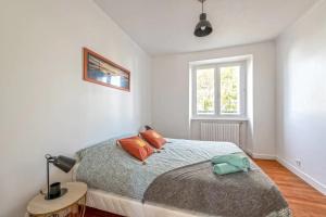 a bedroom with a bed with orange pillows and a window at Maison Charme, Jardin, Brest in Le Relecq-Kerhuon