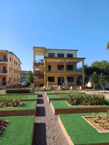 a building with a garden with green grass and buildings at Gaborone Platinum Self Catering in Gaborone