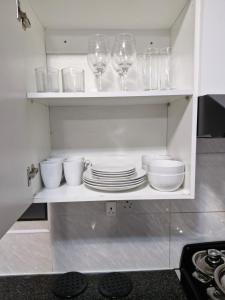 a kitchen with glasses and plates on a shelf at Gaborone Platinum Self Catering in Gaborone