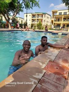 two men laying in the water in a swimming pool at Gaborone Platinum Self Catering in Gaborone