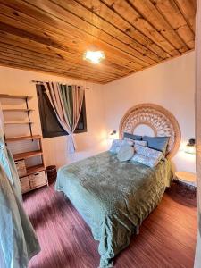 a bedroom with a bed and a wooden ceiling at Lodge Sakayu - Charme, calme & piscine privée in Saint-Louis +15 photos