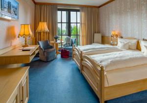 a hotel room with a large bed and a desk at Krone am Park - Gästehaus des Hotel Krone in Alzenau in Unterfranken