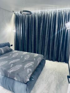 a bedroom with a bed and a blue curtain at Перлина Люкс in Khmelnytskyi