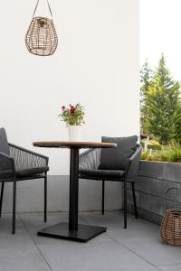 a table and two chairs and a potted plant on a patio at PuraStays - studio 2 in Herzogenaurach