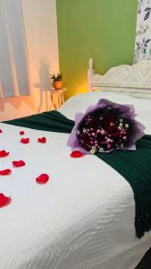 a bed with a bunch of red rose petals on it at Bosque Love in Juatuba