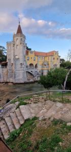 a large castle with a bridge over a river at Casa do Páteo in Alcabideche