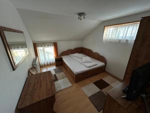 a small bedroom with a bed and a table at Casa in Bucovina in Gura Humorului