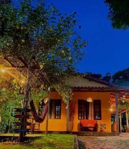 a house with a hammock in front of it at Bosque Love in Juatuba