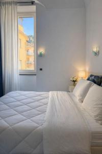 a white bed in a bedroom with a window at In centro - De Jusola apartment in Maiori