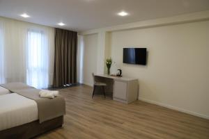 a hotel room with a bed and a desk and a television at Podium Boutique Hotel in Yerevan