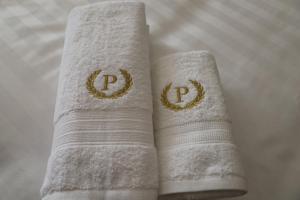 two white towels with gold rings on them at Podium Boutique Hotel in Yerevan