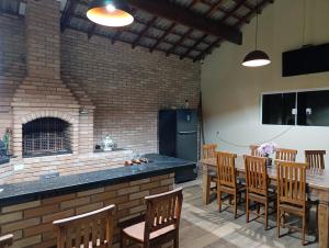 a kitchen with a brick fireplace and a table and chairs at Chácara Paraíso in Itupeva