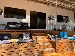 a row of wooden benches with pillows on them at La Sana Surf Hotel, Playa Carmen in Santa Teresa Beach