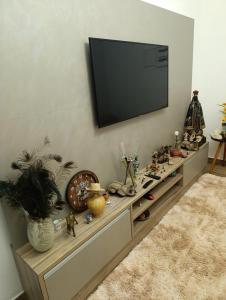 a entertainment center with a television on a wall at Chácara Paraíso in Itupeva