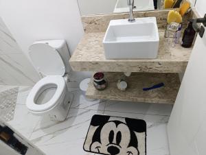a bathroom with a toilet and a sink and a rug at Chácara Paraíso in Itupeva +41 photos