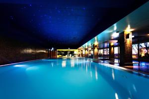 Santana Hotel & SPA في فيلا دو كوندي: مسبح في مبنى فيه انارة زرقاء