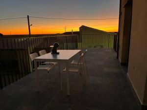 a table and chairs on a balcony with the sunset at Hotel Rural Sol 7 in Piedrahita de Castro