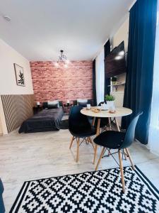 a living room with a table and chairs and a bedroom at Apartamenty Brzeska 10 in Warsaw