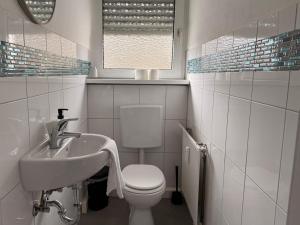 a white bathroom with a sink and a toilet at Ferienwohnung Rheinglück in Oppenheim
