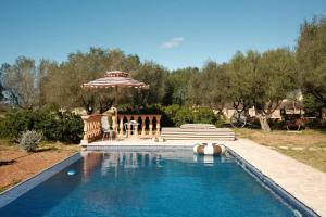 a pool with an umbrella and a table and chairs at La Molina Mallorca in Felanitx