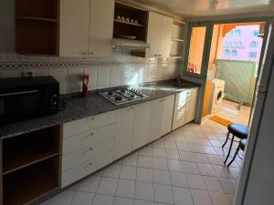 a kitchen with white cabinets and a stove top oven at Al ATLAS résidence in Marrakesh