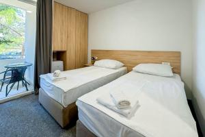 a room with two beds and a table and a window at hotel depandance Imperial Green by GLOBTOUR in Vodice