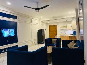 a living room with two blue chairs and a tv at Prime Stays Rezidor in Rawalpindi +3 photos