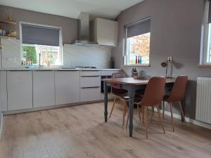 a kitchen with a table and chairs in it at Vakantiehuis in Oosterwolde +6 photos