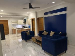 a living room with a blue couch and a table at Prime Stays Rezidor in Rawalpindi