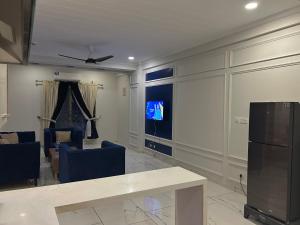 a living room with a table and chairs and a tv at Prime Stays Rezidor in Rawalpindi