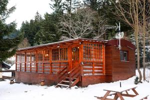 a wooden cabin in the snow with a picnic table at Chata Bella Donovaly in Donovaly