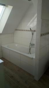 a white bath tub in a room with a window at Apartmenthaus Rosenflair in Schönebeck +42 photos