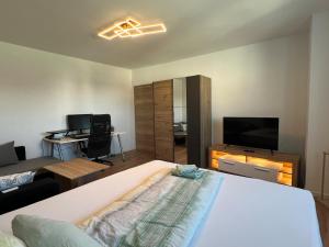 a bedroom with a bed and a desk and a television at Ferienwohnung Wanderlust in Marsberg