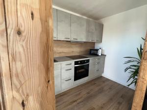a kitchen with white cabinets and a stove top oven at Ferienwohnung Wanderlust in Marsberg