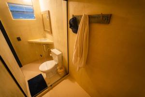 a small bathroom with a toilet and a sink at Hostel Tainha Caraíva in Caraíva