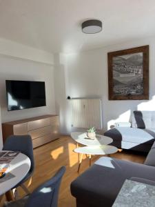 a living room with a couch and a tv at Alpenlodge in Wenns