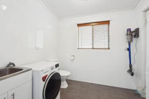 a white bathroom with a toilet and a sink at Sea Chain in Lancelin