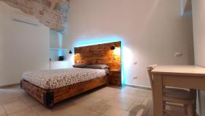 a bedroom with a bed with a wooden headboard at ''B&B Santa Rita Corato fitta camere'' in Corato