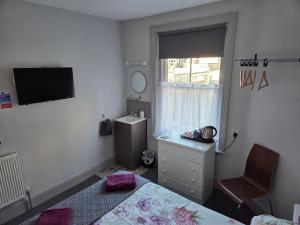 a bedroom with a bed and a sink and a window at Burlington in Margate